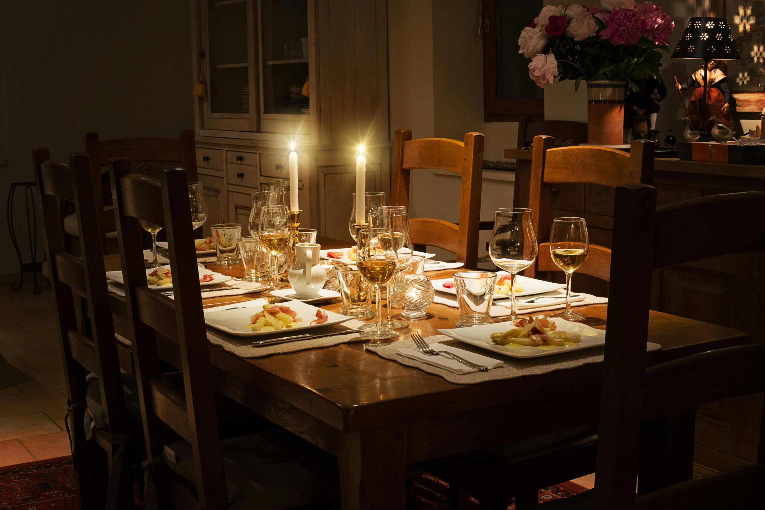 Two candles are lit on a family dinner table